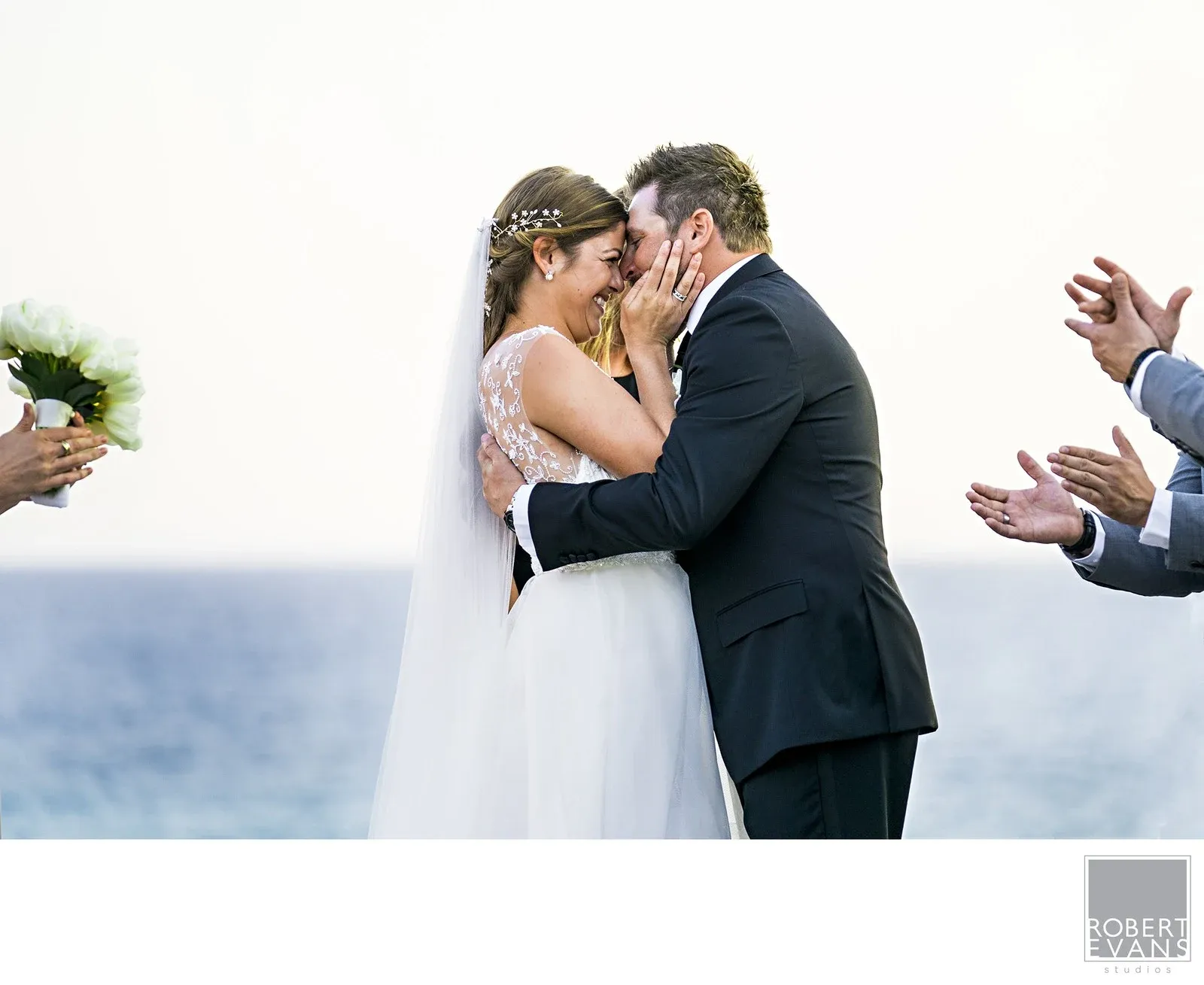 Celebrate With Friends Close At Hand A wedding kiss framed by applauding guests