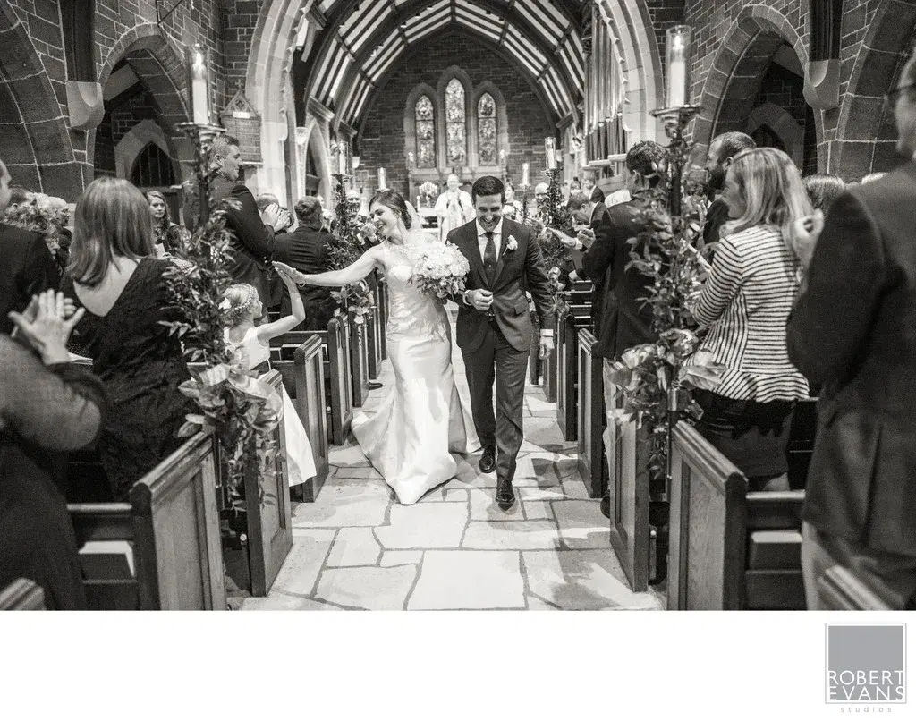 A bride and groom walking down the aisle of a crowded church A bride and groom walking down the aisle of a crowded church